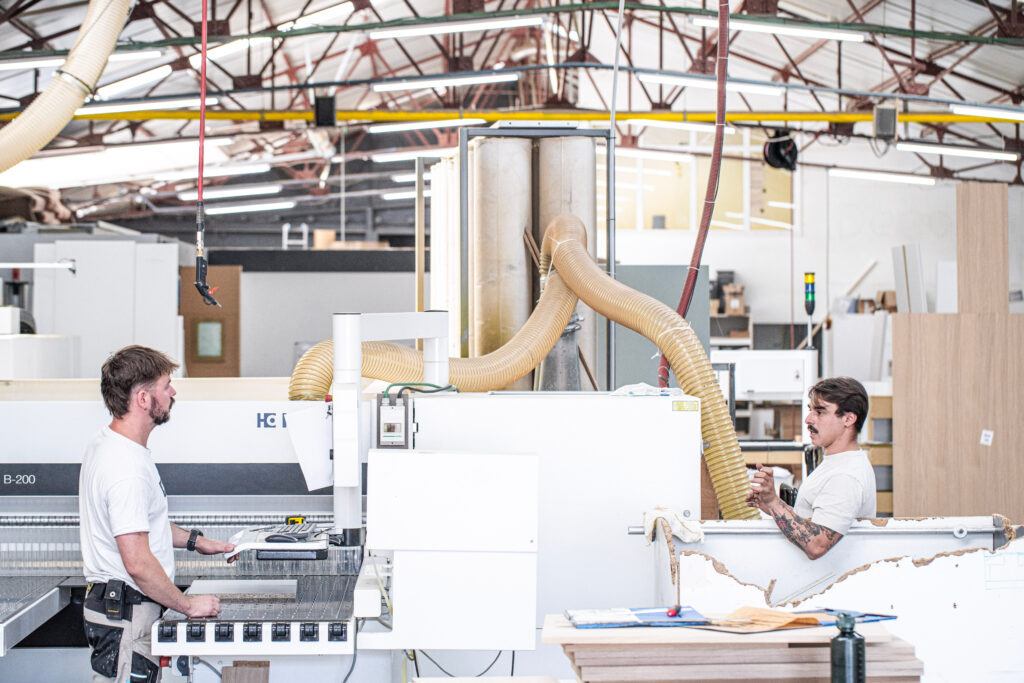 Two craftsmen working with HOMAG woodworking machinery in La Menuiserie's production workshop